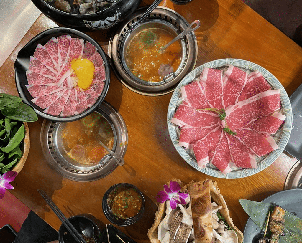 Two selections of meat, veggies, and two pots of broth at Chubby Cattle Hot Pot in Las Vegas